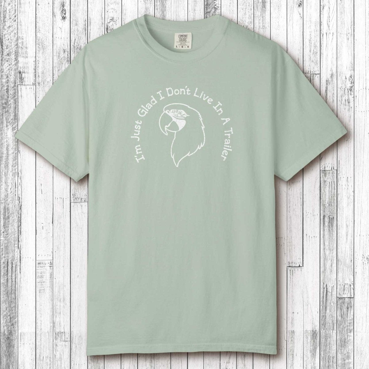 Mint green t-shirt with white graphic and text on a wooden surface