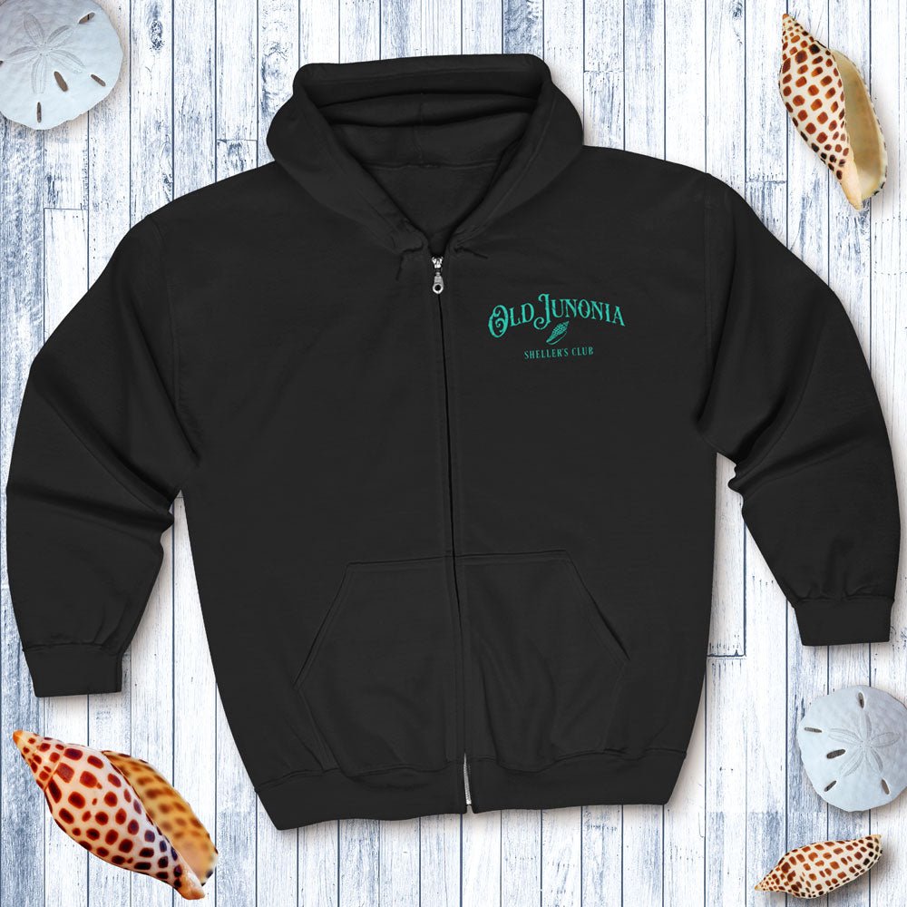 Black hoodie with 'Old Junonia' logo on a wooden surface with seashells.