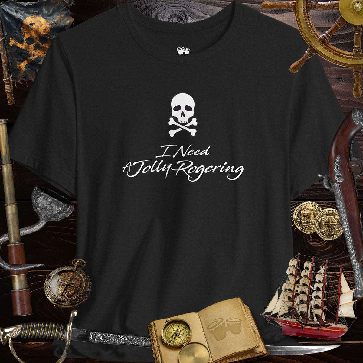 Funny pirate saying T-Shirt features 'I Need A Jolly Rogering' with skull and crossbones design on a black Bella Canvas tee.