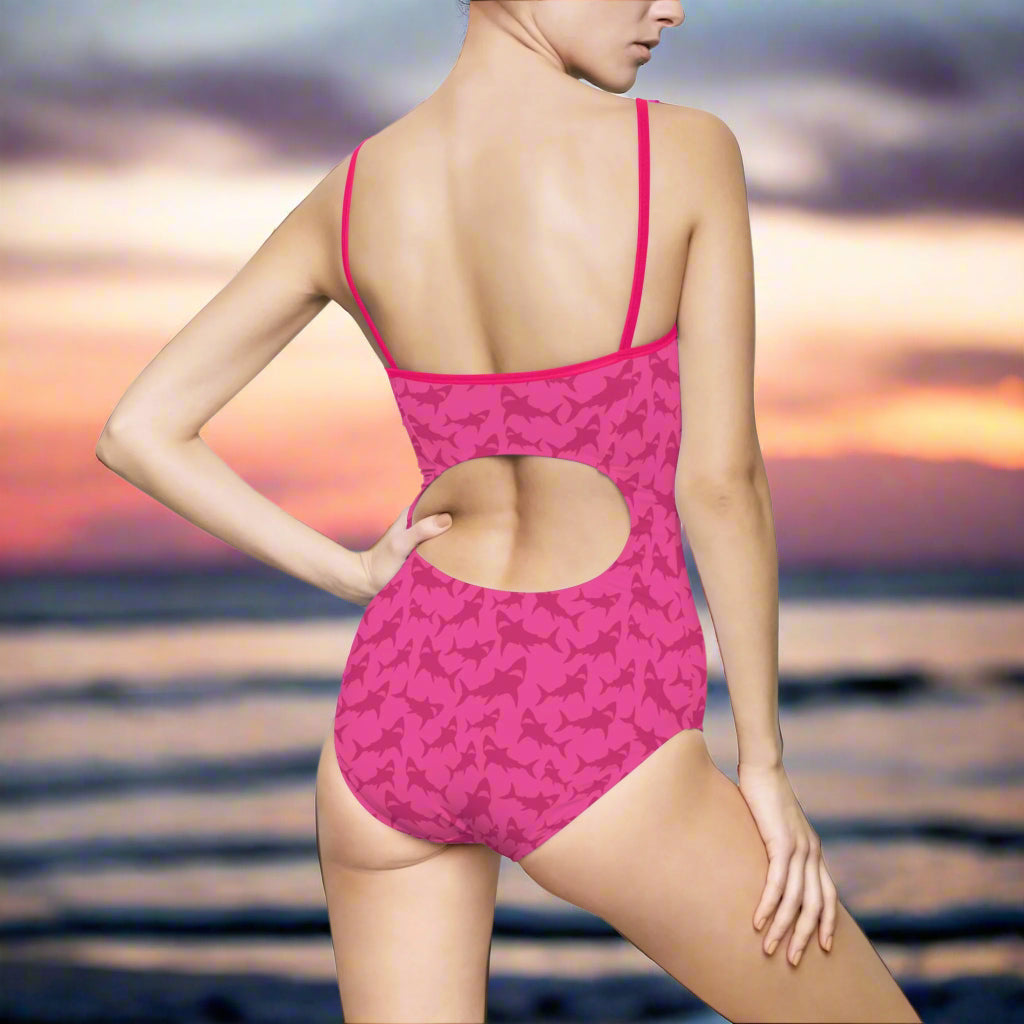 Woman in Hot Pink Cut OUt One Piece Bathing Suit standing in sand near the ocean