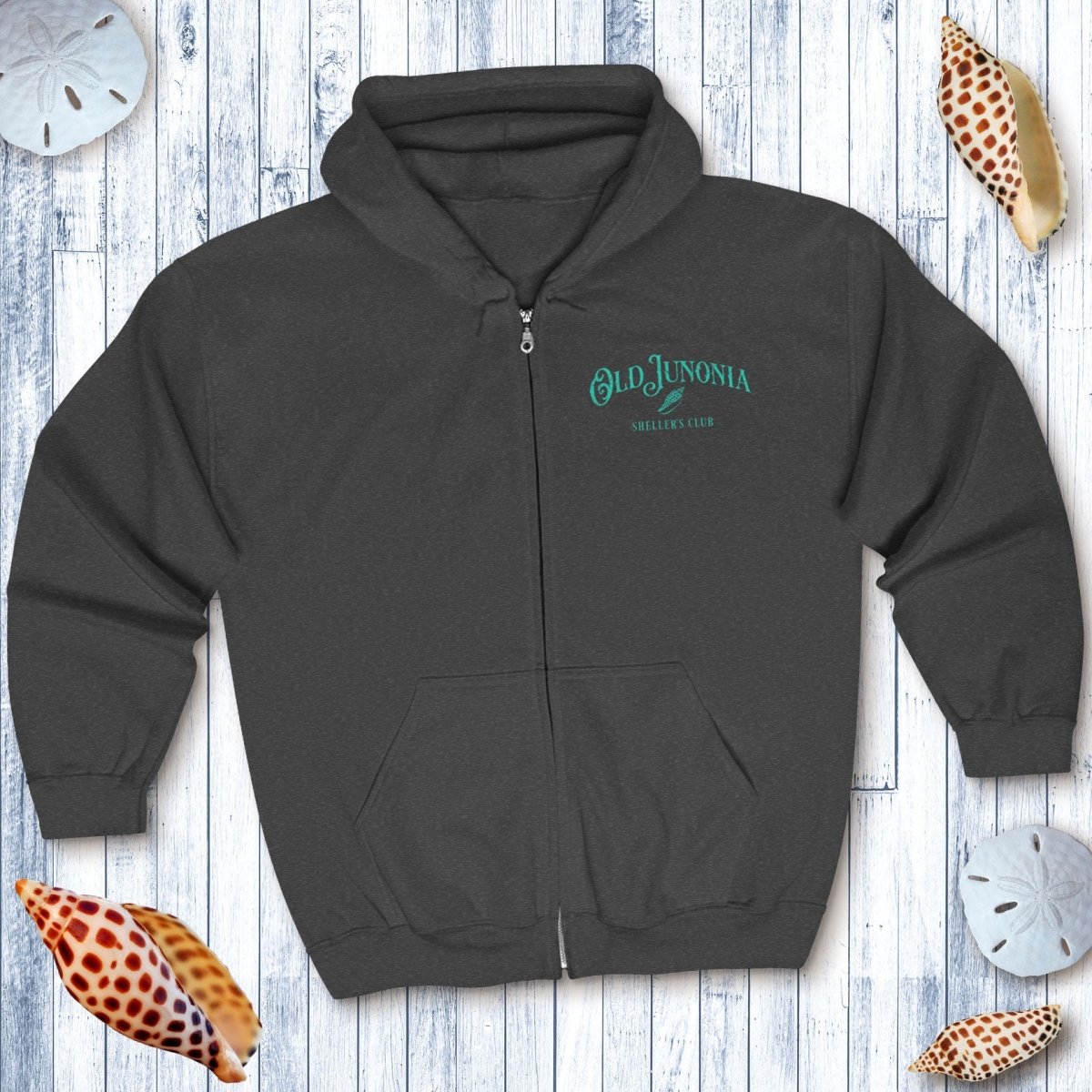 Dark gray hoodie with 'Old Junonia' logo on a wooden surface with decorative shells.