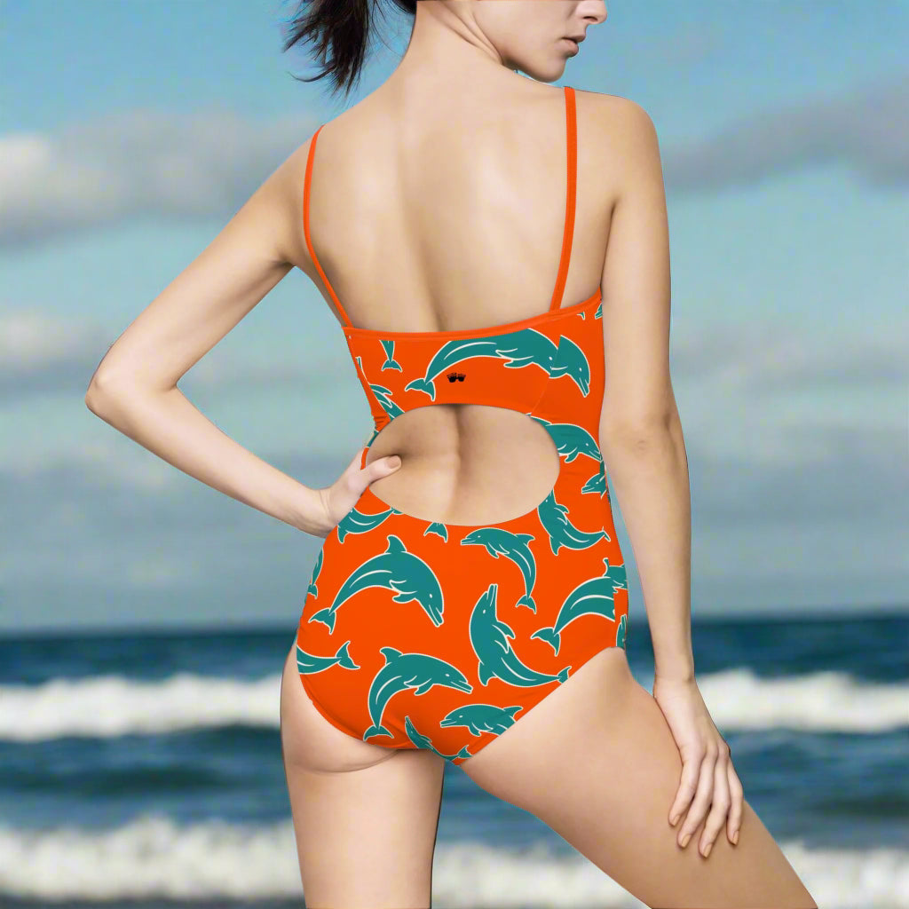 Model wearing Orange Dolpnin One Piece Bathing Suit Facing The Ocean