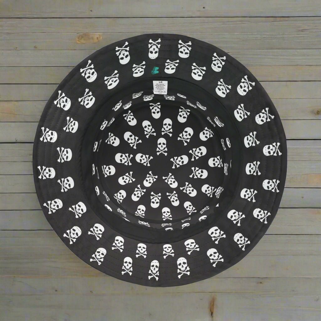 Black Pirate bucket hat with white skull & Crossbones pattern upside down on a fishing pier