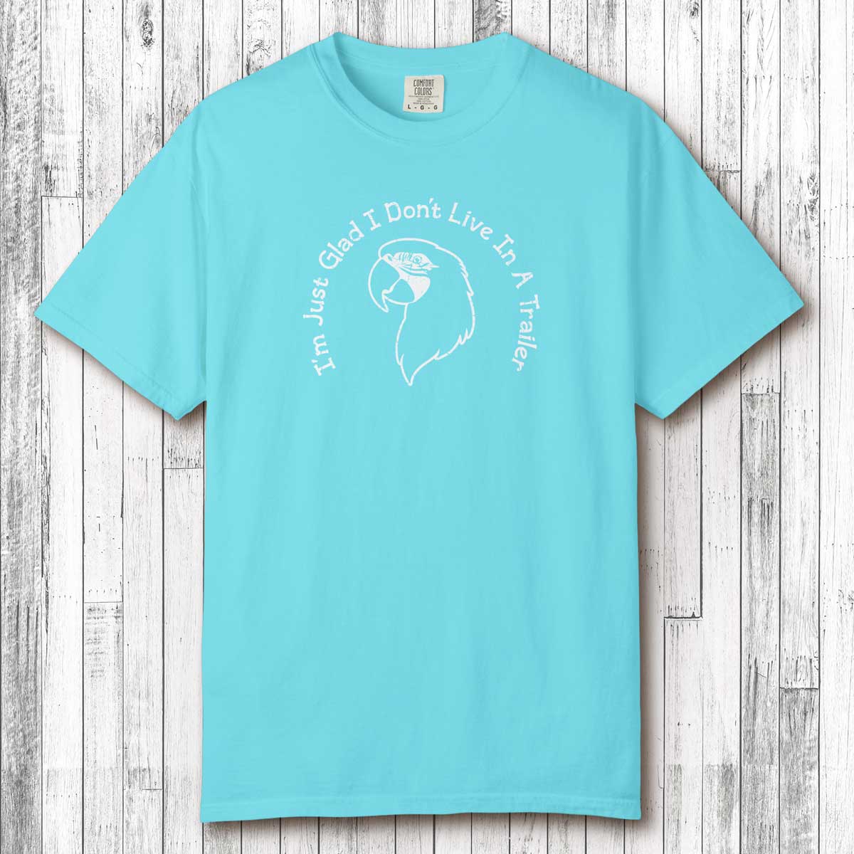 Turquoise t-shirt with white graphic and text on a wooden surface