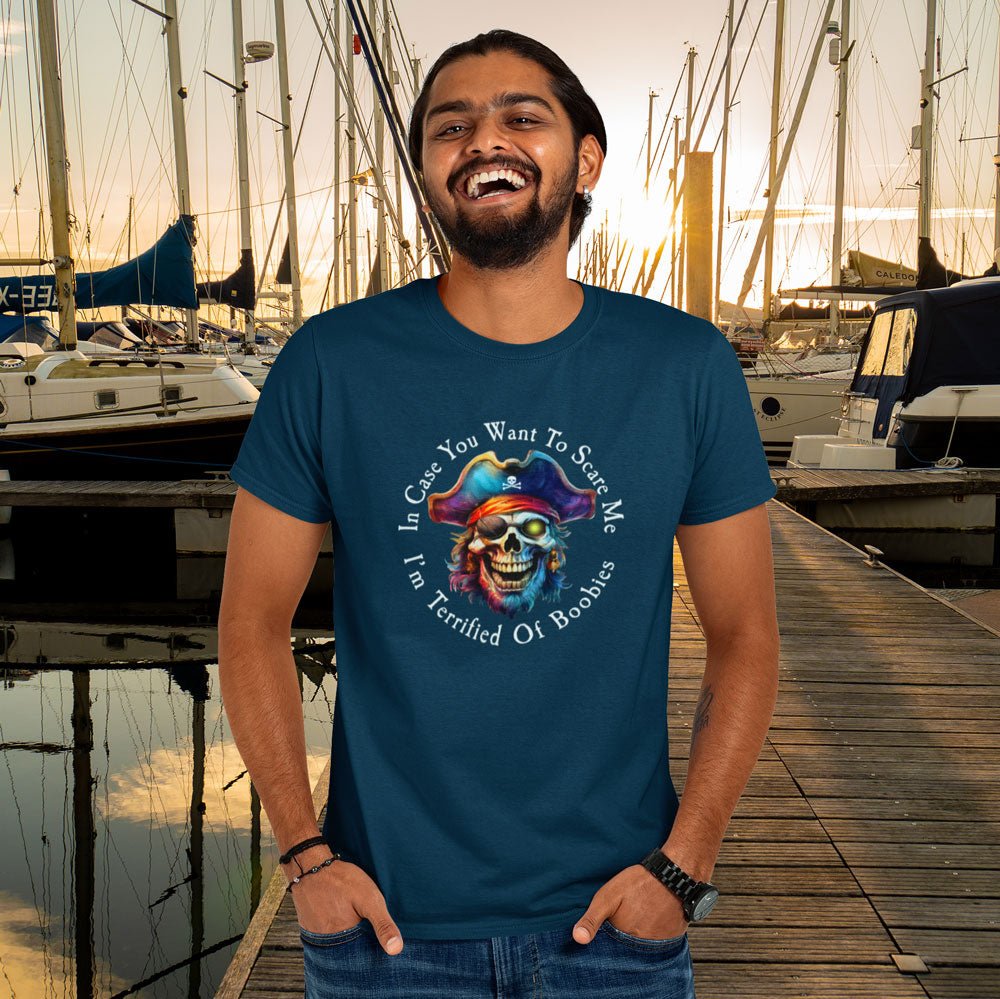 Man wearing a blue t-shirt with a colorful skull design and text at a marina.