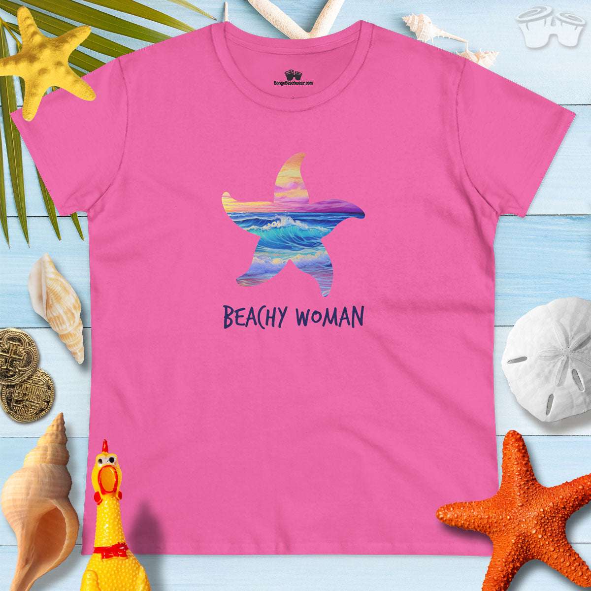 Bright pink t-shirt with a starfish design and 'BEACHY WOMAN' text, perfect for summer and beach getaways.