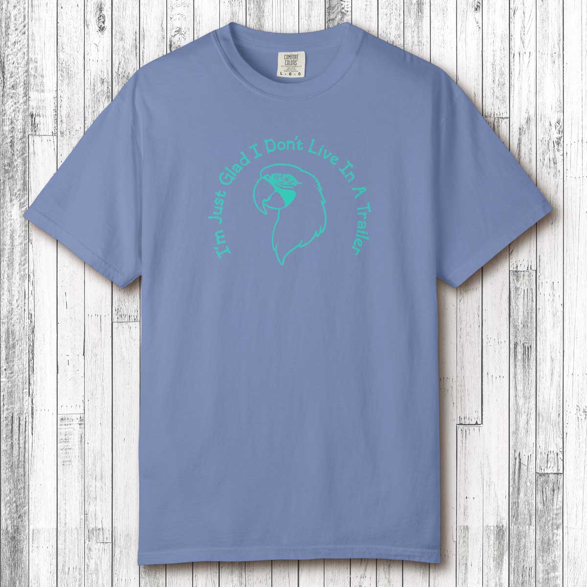 Blue t-shirt with teal graphic and text on a wooden surface