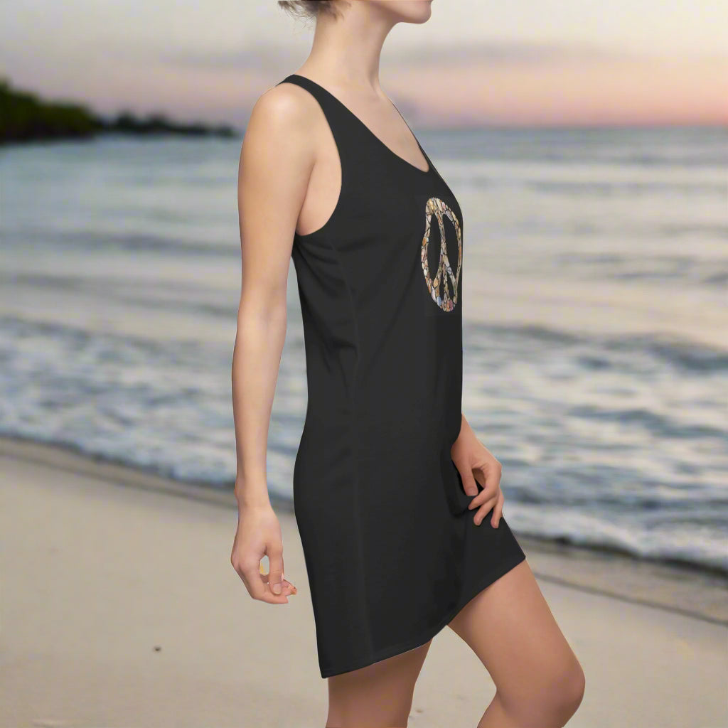 Black Tank-Top Dress with seashells arranged into a peace sign worn by swimsuit model on fashion island beach