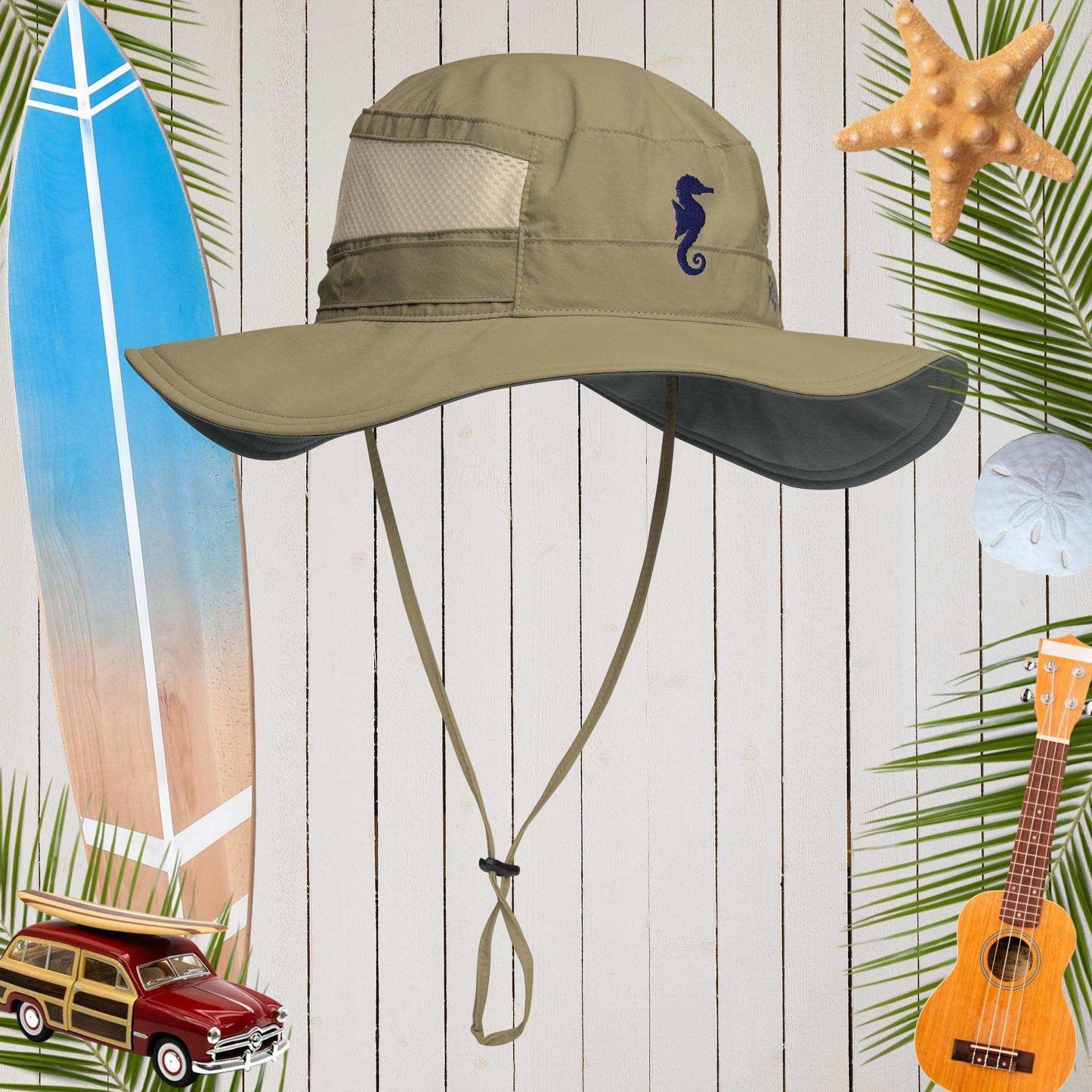 Sage Columbia sun hat with seahorse embroidery on a wooden background with beach-themed items.
