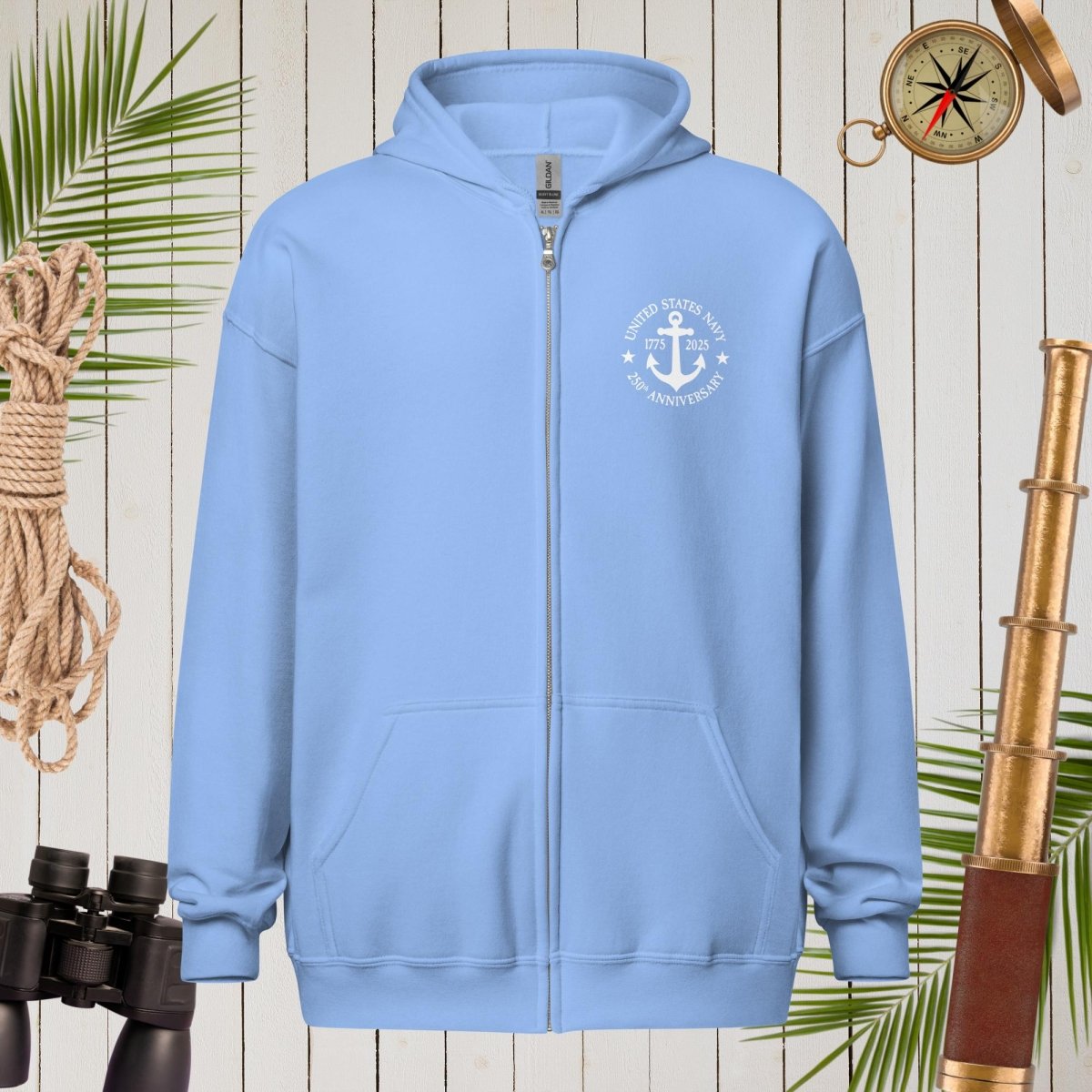 Light blue hoodie with a logo on a wooden background with nautical items.
