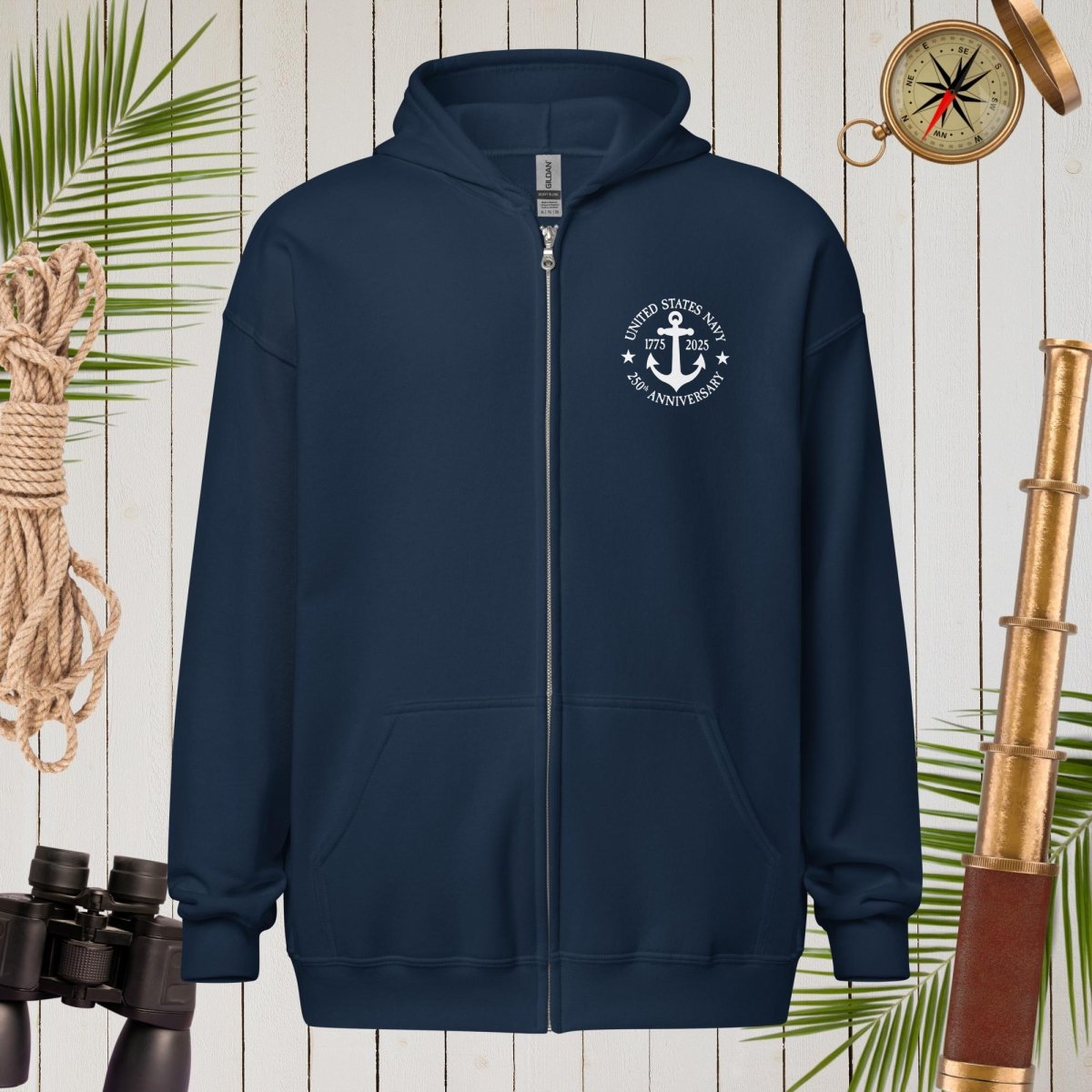Navy blue hoodie with a white emblem on a wooden background with nautical items.