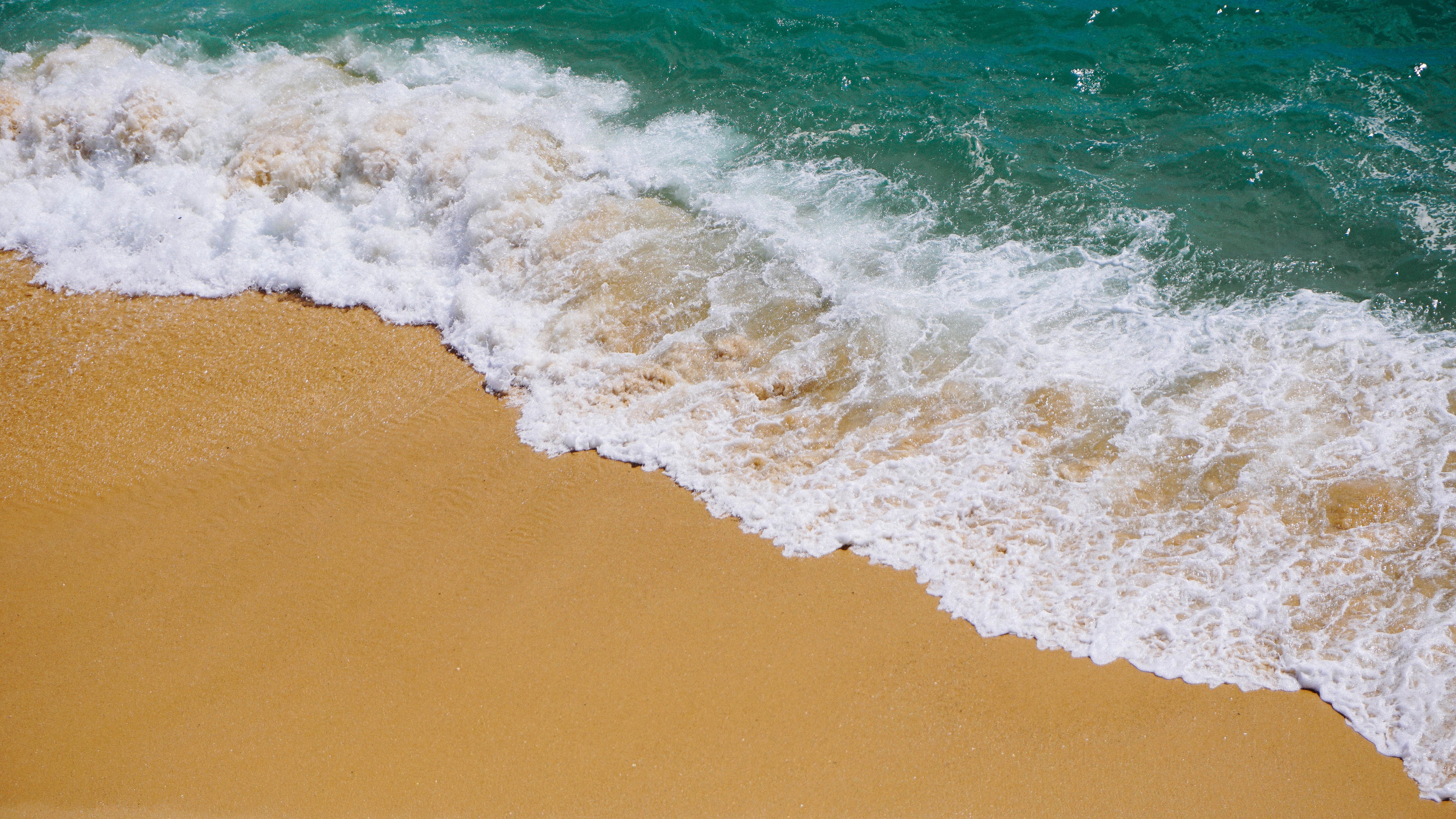 ocean wave over sand