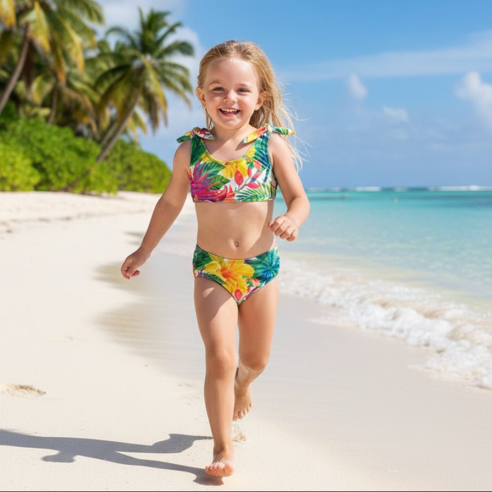 Cute little girl wearing a Colorful Kids Tropical Bikini set playing on a tropical island beach