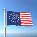 Flag with '1776 2026 250 Years of Freedom' text against a blue sky
