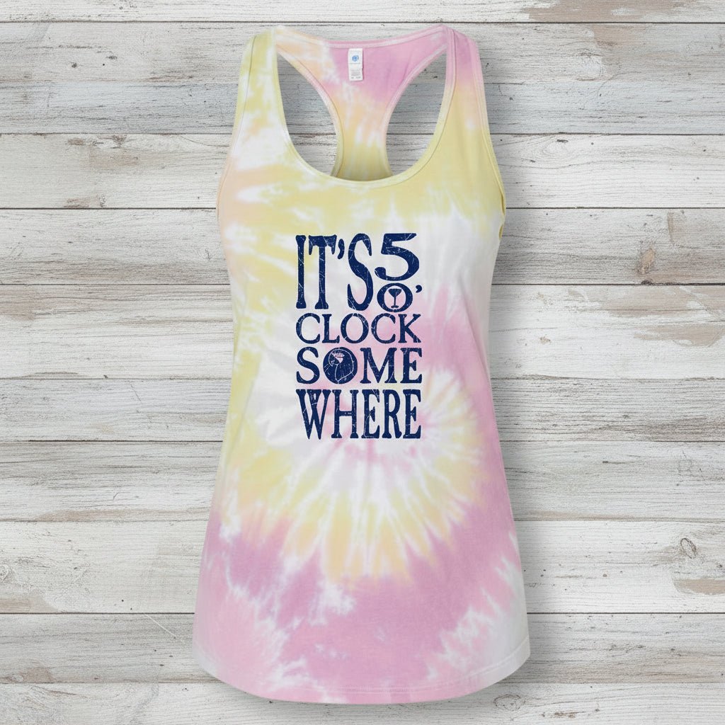 A women's racerback tank top with a pastel tie-dye pattern in pink, yellow, and white, featuring the text 'IT'S 5 O' CLOCK SOME WHERE' printed in navy blue on the front.