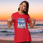 Woman wearing a red 'AMI Strong' t-shirt on a beach at sunset