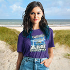 Woman wearing a purple Fundraiser Tee with 'AMI STRONG' on a beach