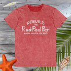 Red t-shirt with 'Rebuild the Rod & Reel Pier Anna Maria Island' text on a wooden background with beach elements.