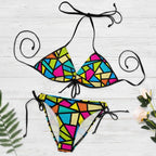 Colorful geometric bikini set on a white background with decorative elements.