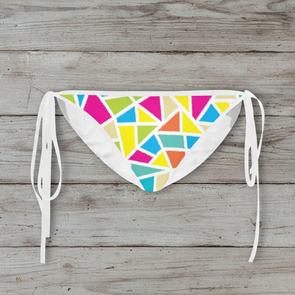 Colorful geometric patterned bikini bottom on a wooden surface