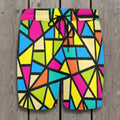 Colorful geometric patterned shorts laying flat on a rustic wood deck