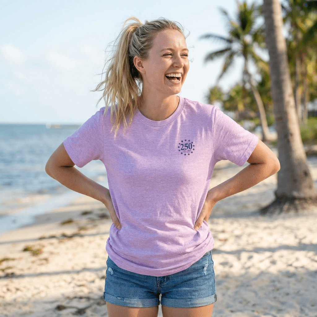 Woman wearing a pink t-shirt with a USA 250th Anniversary logo on a beach