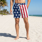 Person wearing American flag patterned shorts on a tropical island beach