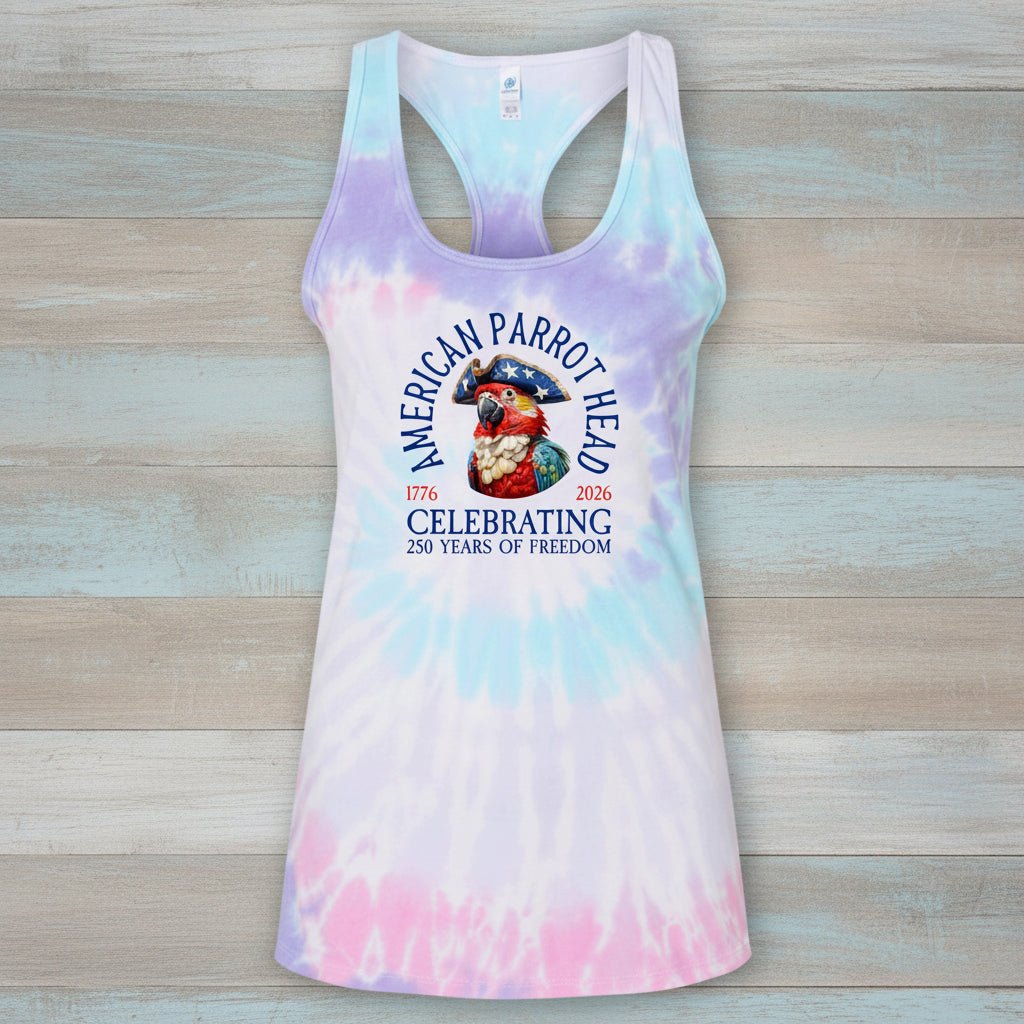 A women's racerback tank top with a pastel tie-dye pattern in purple, blue, and pink, featuring a central graphic of an American parrot and the text 'American Parrot Head Celebrating 250 Years of Freedom'.