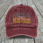 Maroon cap with 'US25' design on a wooden surface