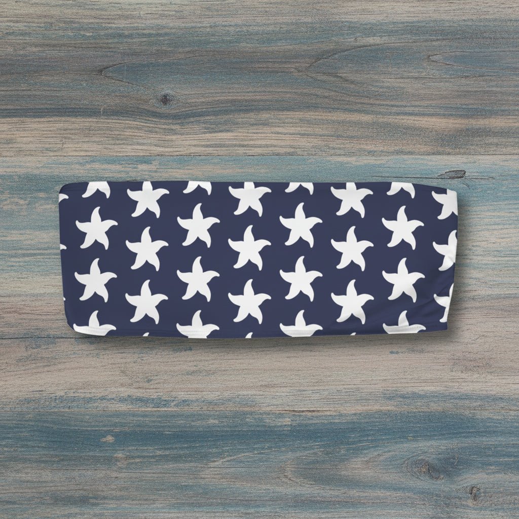Navy bandeau top with white starfish pattern on a nautical wood background