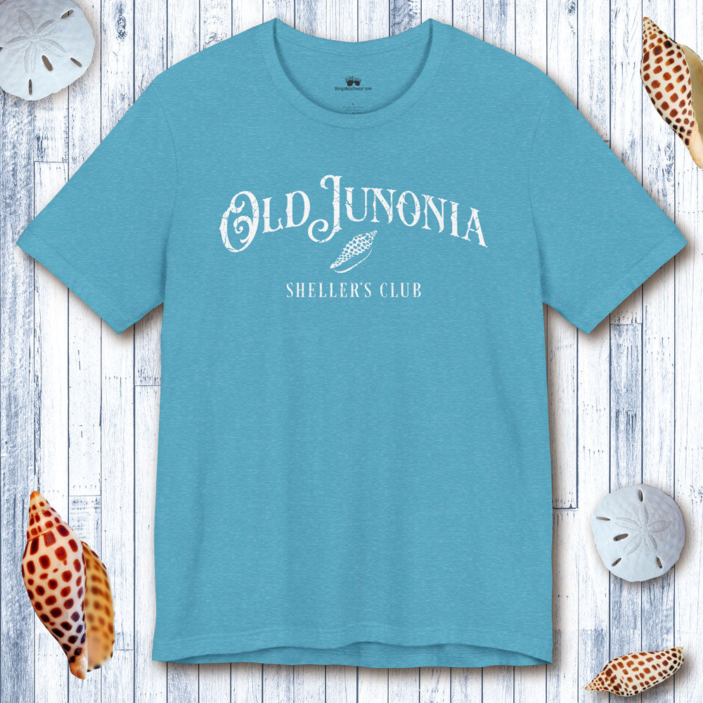 Blue t-shirt with 'Old Junonia Sheller's Club' text on a wooden surface with shells.