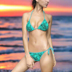 Aqua Floral pattern bikini worn by model standing near the ocean