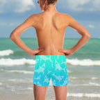 Person wearing turquoise swim shorts with shark pattern watching the waves at the beach in Key West