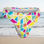 Colorful geometric patterned swim brief on a faded beach background