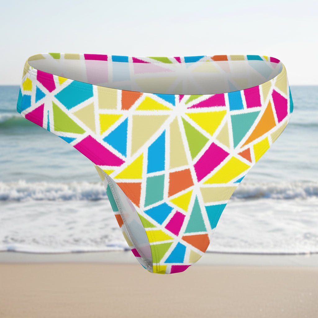 Colorful geometric patterned swim brief on a faded beach background