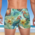 Tropical-themed swim shorts with parrots and flowers on a beach background