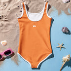 Back of Girl's Orange One Piece Swimsuit laying in the sand