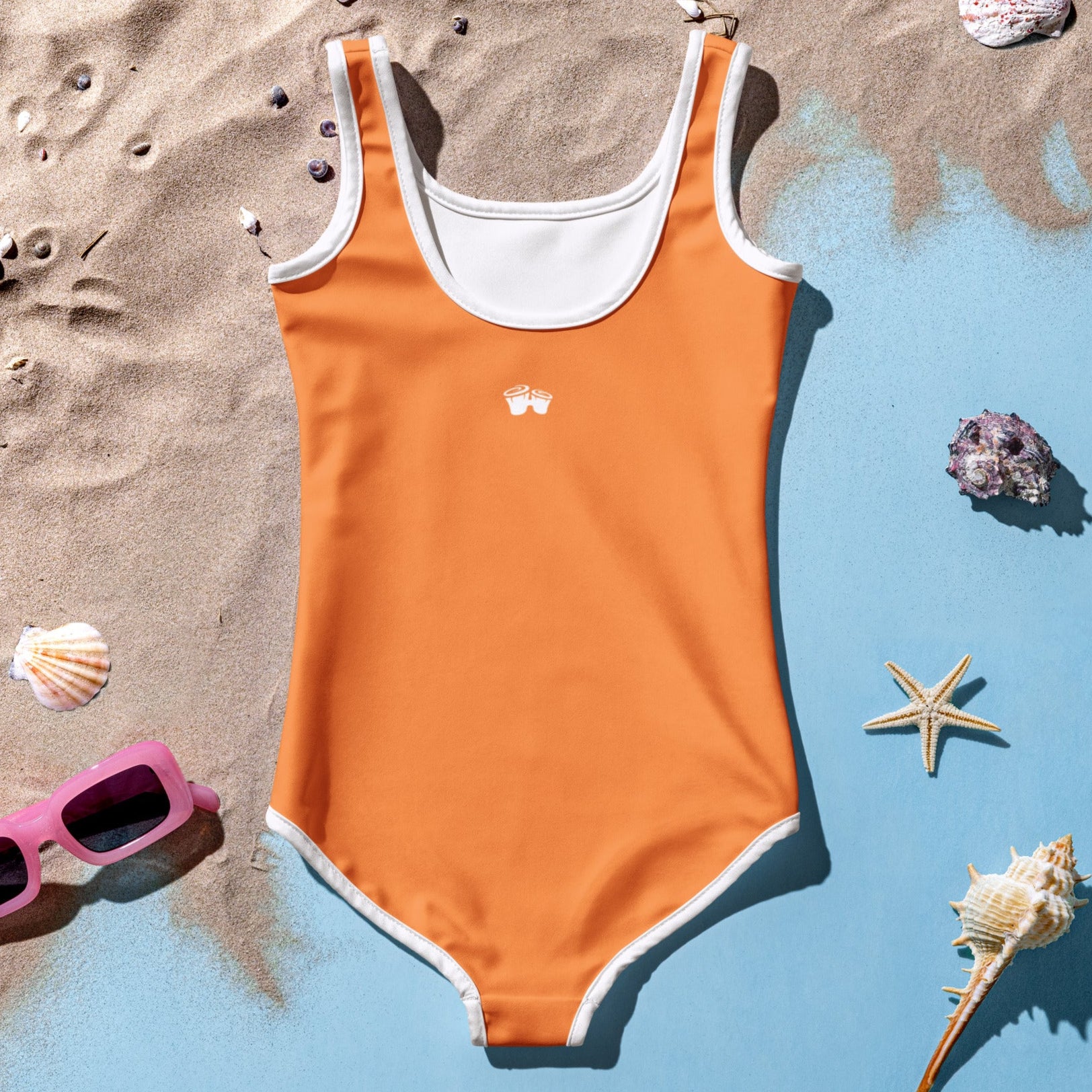Back of Girl's Orange One Piece Swimsuit laying in the sand
