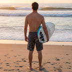 Dude wearing infinite shark pattern board shorts looking at the waves from  La Jolla Beach