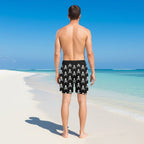 Black shorts with white skull and crossbones pattern worn by a person on a tropical beach