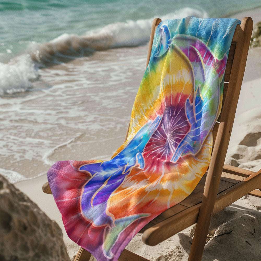 Dolphin tye dye beach towel laying over a deck chair on the beach