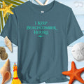 Beachy Bella Shelling T-Shirt featuring 'I Keep Beachcomber Hours' text on a blue background with shells and starfish decor.