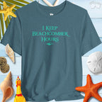 Beachy Bella Shelling T-Shirt featuring 'I Keep Beachcomber Hours' text on a blue background with shells and starfish decor.