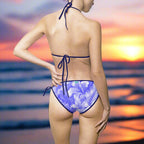 Model in blue floral bikini facing the ocean