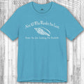 Blue Wanderlust t-shirt with white text and seashell graphic on a wooden surface