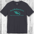 Navy blue Wanderlust t-shirt with teal text and seashell graphic on a wooden surface