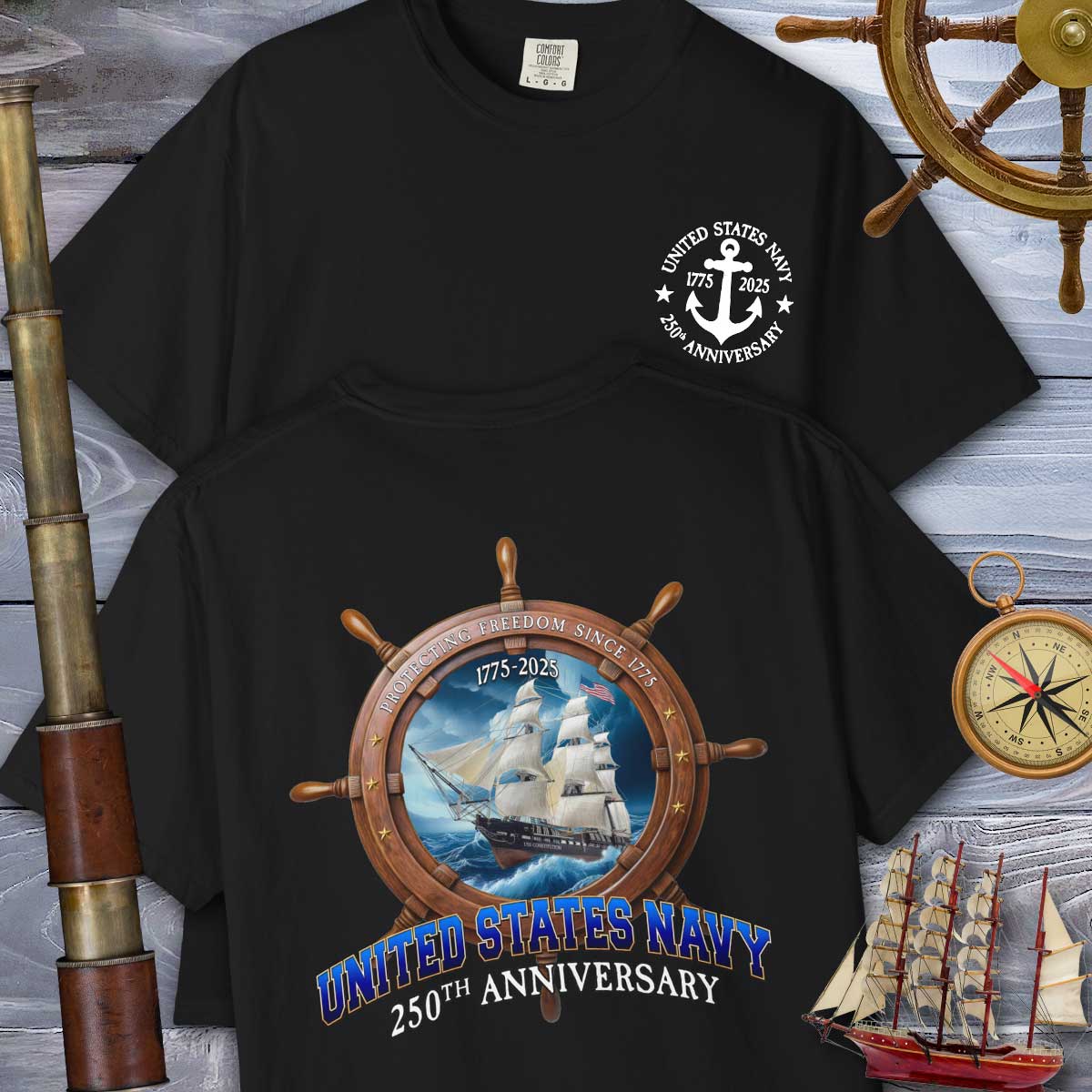 Black t-shirt with United States Navy 250th Anniversary design on a wooden background with ship and compass elements.