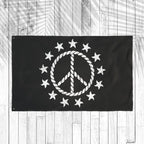 Black flag with white peace symbol and stars on a wooden background