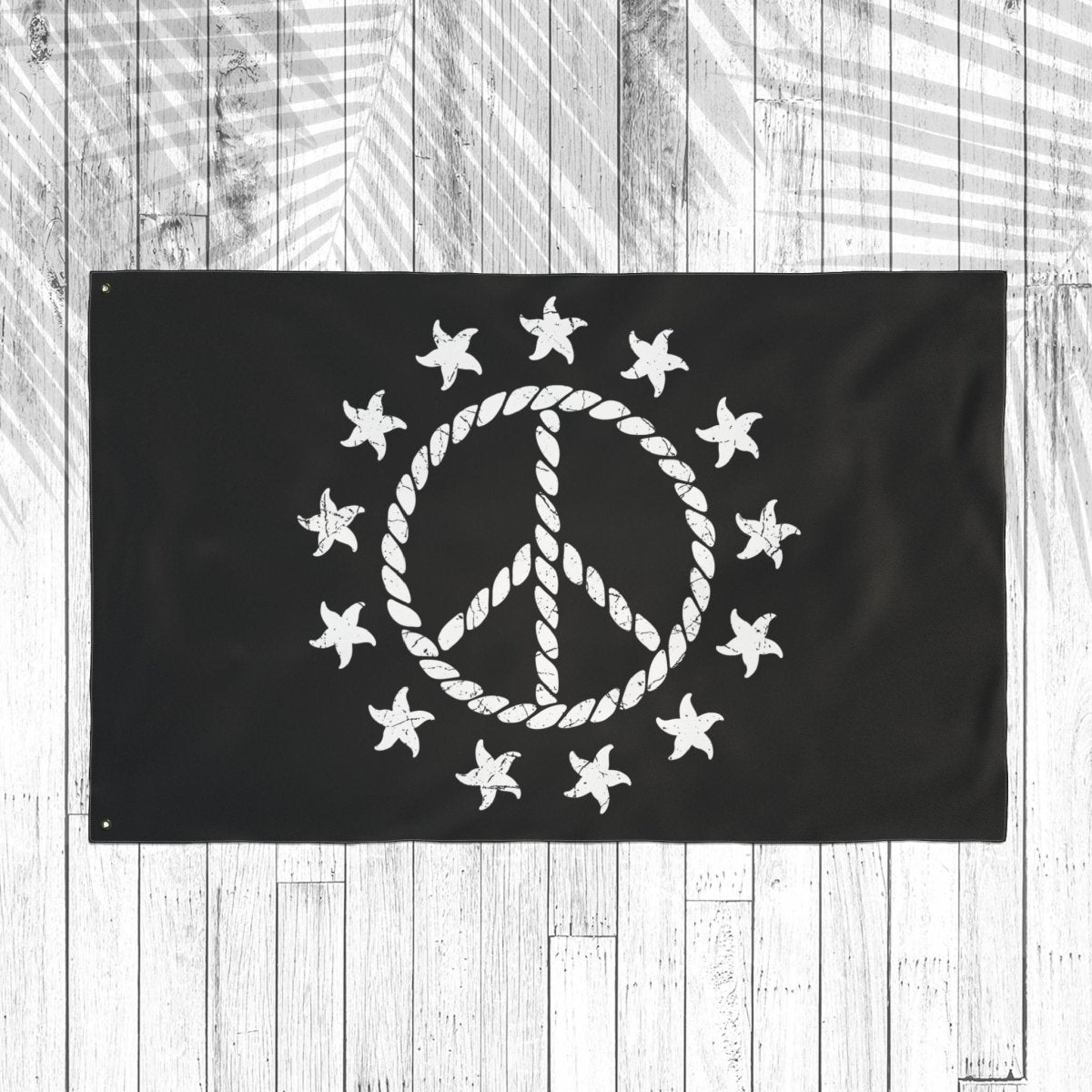 Black flag with white peace symbol and stars on a wooden background