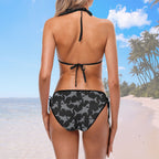 Woman wearing a black bikini with shark pattern on a beach